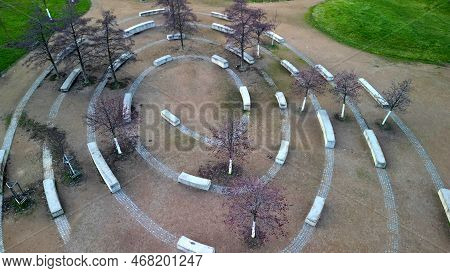 Massive Concrete Blocks Of Bench In The Park Are Connected By Granite Blocks In The Shape Of A Spira