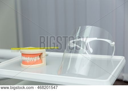 Clean Teeth Dental Jaw Model And Yellow Thooth Brush On Gray Background.