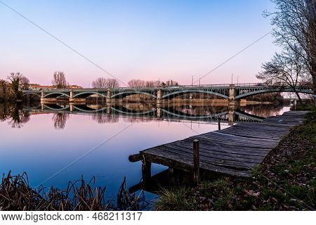 Pier And Enrique Estevan Iron Bridge Reflected On The Tormes River At Sunset