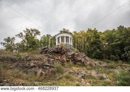 White Gazebo In City Park Of Zhytomyr, Ukraine At Sunny Autumn Day. Picturesque View On Colourful Hi