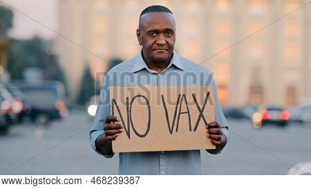 People Vaccination Phobia Concept. Adult Elderly African American Man Stands In City Street Holding 