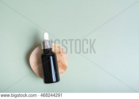 Cosmetic Bottle With Pipette On Wooden Slice  Top View, Flat Lay On Colored Background With Lavender