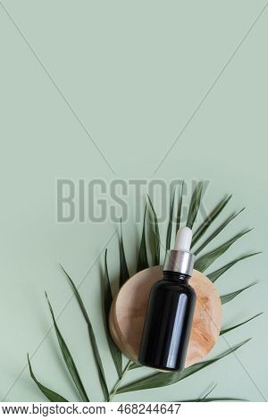 Cosmetic Bottle With Pipette On Wooden Slice  Top View, Flat Lay On Colored Background With Nature D