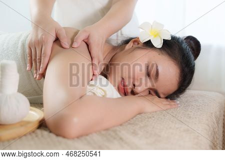 Young Woman Doing Relaxing Massage In Spa Salon. Female Being Massaged By A Masseur. Spa And Medicin