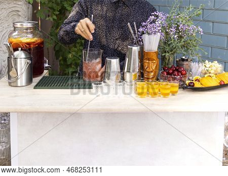 Glasses Of Cocktails On The Bar. Bartender Pours A Glass Of Sparkling Wine With Red Alcohol. Barman 