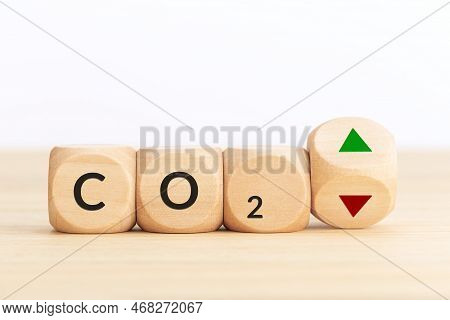 Co2 Emissions Up Or Down Concept. Symbol On Wooden Blocks And Turning Dice With Up And Down Arrows. 