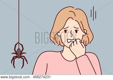 Frightened Woman Puts Hand To Face When Sees Large Spider Descending From Ceiling Along Web. Young G
