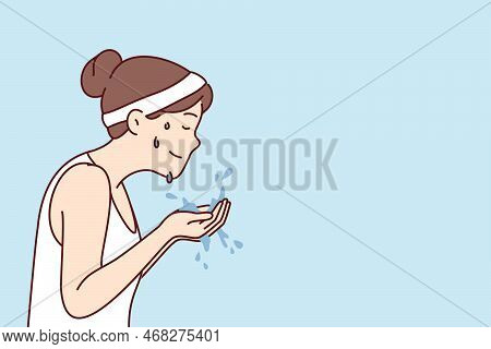 Woman With Sports Headband On Hair Holds Water In Palms Wanting To Wash Face After Fitness Or Mornin