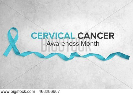 Photo Of Teal Ribbon With Curled End Atop A Light Concrete Background. Modern Sans Serif Typography