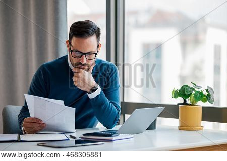 Focused Entrepreneur, Lost In His Thoughts At The Office, Checking The Business Plans Of The Company