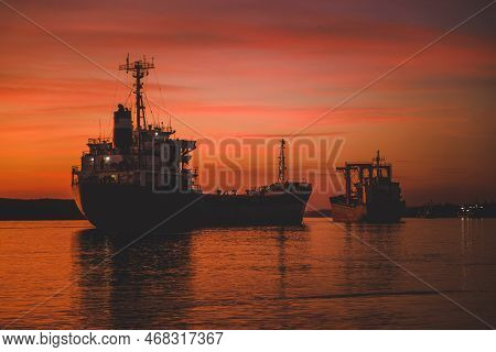 Cargo Ship On The Coast At Sunset. Logistics And Transportation Of International Cargo Ship. Freight