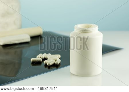 White Bottle With Calcium Capsules And X-ray Film On Docktor Desk