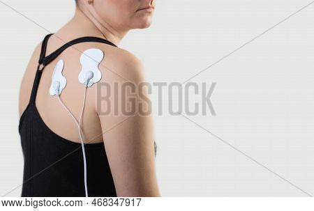 Acupuncture Electronic Massager On The Girl's Back To Relax Muscles And Relieve Back Pain. Home Phys