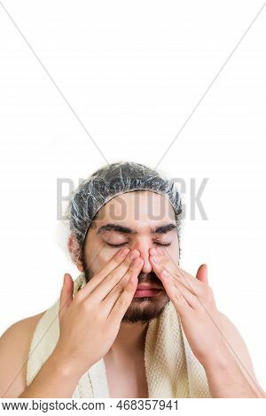 Young Man Applying Cosmetic Mask On Face In Spa Salon.