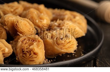 Honey Baklava With Walnuts In A Black Plate Close Up On Dark Wood Background