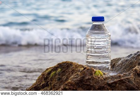 Pebbles In Pyramid One Over Another And Bottle With Drinking Water