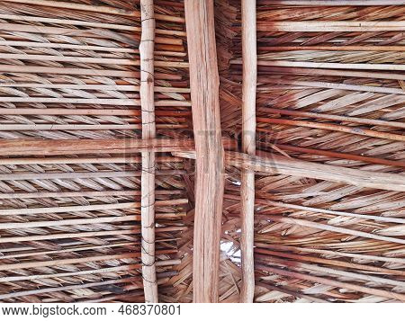View From Below Of The Palm Leaf Roof. Close Up Of Rustic Roof Made Of Wood, Straw And Dry Leaves. A