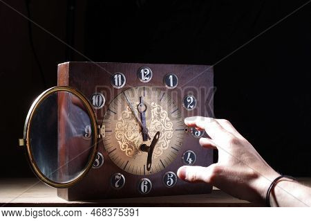 Reaching For The Clock. Hold On To The Passing Time. Hand And Big Clock With Arrows. Leaving Chance.