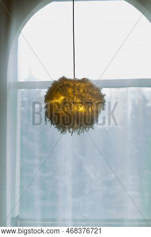 Modern Electric Lamp With Abajur Made Of White Feathers, Gives Romantic Light In Room, Hangs Against