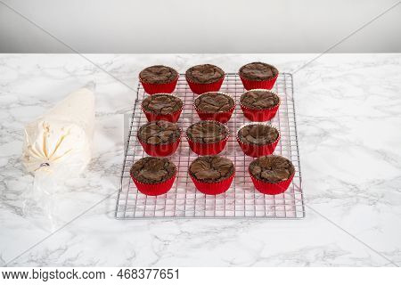 Piping Peppermint Buttercream Frosting On Top Of The Chocolate Cupcakes And Decorating With Crushed 