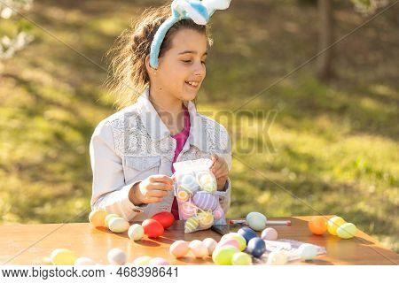 Teenage Girl Paints Easter Eggs In The Garden.