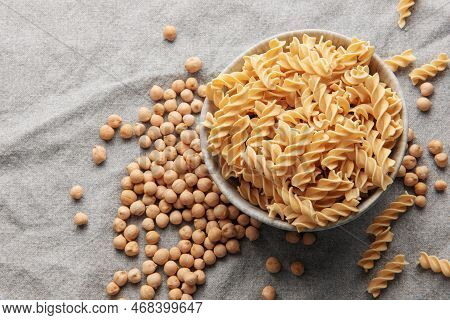 Chickpea Bean Fusilli Pasta On A Gray Textile Background. Bowl With Raw Pasta And Chickpea Bean. Glu