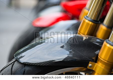 Motocykl detail, uhlíkových vláken bláto stráž a zlatý tlumiče