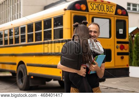 Parent Taking Child To School. Pupil Of Primary School Go Study With Backpack Outdoors. Father And S