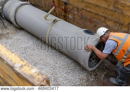 Builder Installing Big Diameter Concrete Drainage Pipe Protected By Trench Support System During Dee