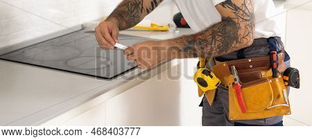 Craftsman Installs Hob In Kitchen. Household Appliance Installation Services Concept
