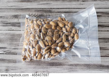 Vacuum-packed Dried Almond Nuts On A Wooden Background. Plant-based Diet, Healthy Fats, Keto Diet, L