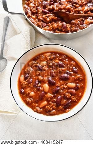 Cowboy Beans With Ground Beef, Jalapeno Pepper And Bacon In Bowl Over White Stone Background.