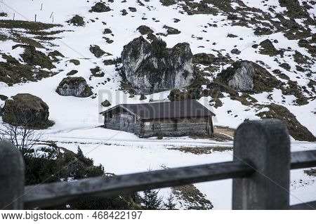 Kaltenbach ​hochfugen, Austria - 9 Jan, 2020: An Old Farmhouse Under A Large Stone Cliff