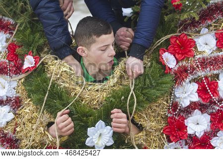 Krasnoilsk, Ukraine - 13 Jan 2017: Dressing A Young Boy In A Straw Bear Costume On Malanka