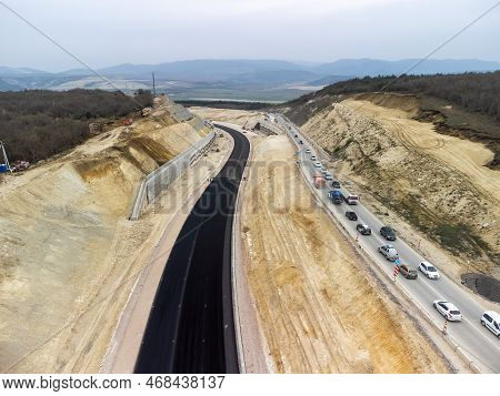 Mountain Road Constraction. Workers Reinforce The Slope Over The New Road. Road Construction In Prog