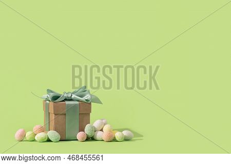 Happy Easter Minimal Concept. Many Tiny Eggs Sweets And Gift Box With Bow On Spring Yellow Green Edg