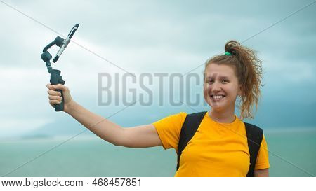 Beautiful Young Girl Blogger Outdoors Walking, Traveling, Hiking, Holding Stabilizer Or Gimbal With 