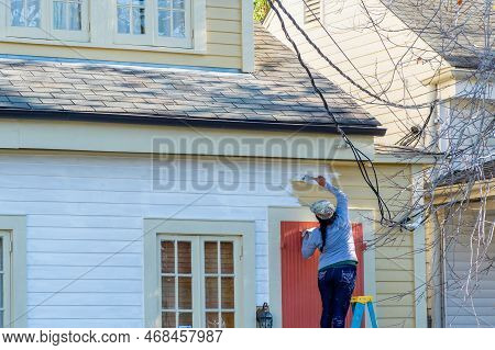 New Orleans, La - December 7: Woman Standing On A Ladder And Painting The Siding Of A House In Uptow