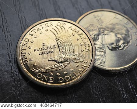 American Coins Close Up Lie On Dark Surface Of Office Table. Soaring Eagle Sacagawea Dollar Coin. Us
