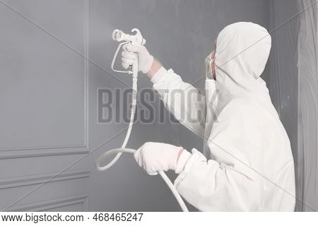 Decorator Dyeing Wall In Grey Color With Spray Paint