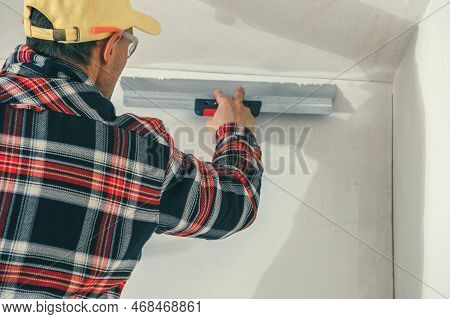 Professional Construction Worker Applying Plaster On Walls Using Plastering Spatula Tool. Interior R