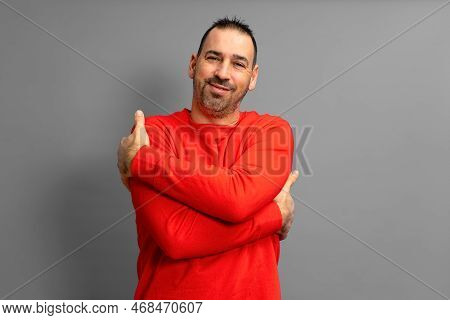 I Love Myself. Portrait Of An Egotistical Bearded Dark-haired Man In A Red Pullover With His Eyes Cl