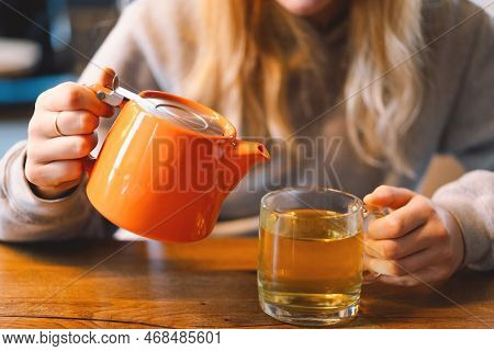 Portrait Of A Joyful Teengirl Enjoying A Cup Of Tea At Cafe. Smiling Beautiful Girl Drinks Hot Tea I