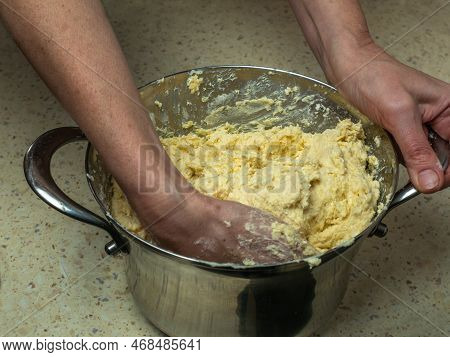 Female Hands Knead Fresh Dough For Baking Bread In An Iron Pan. Close-up Of Dough Preparation. With 