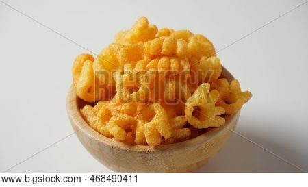 Cheetos Is A Crunchy Corn Puff Snack. Bright Orange Cheese Puffs In A Wooden Bowl.