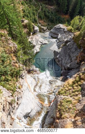 View From Above Of Lillaz Waterfall (cascate Di Lillaz) And Emerald Pond Below, Rocks Around Covered