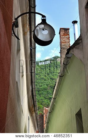 Street lamp hanging in a narrow street in Brasov, Romania