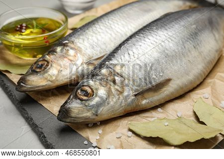 Slate Plate With Salted Herrings, Oil And Spices On Grey Table, Closeup