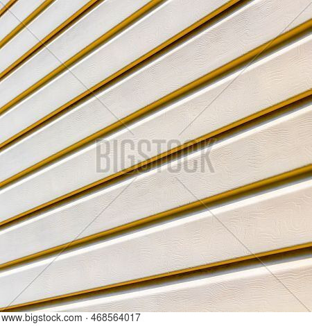 Part Of The Wall Of A Private House Covered With Plastic Beige Siding.