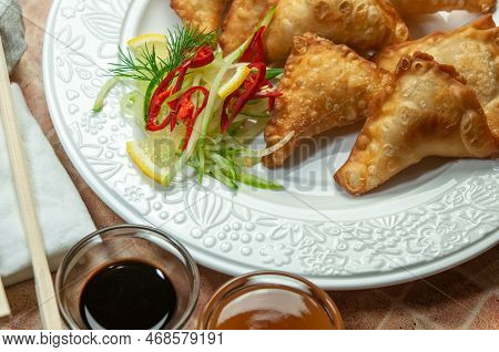 Asian Fried Dumplings Wontons With Soy And Sweet And Sour Sauce On White Dish. Fried Dumplings Gyoza